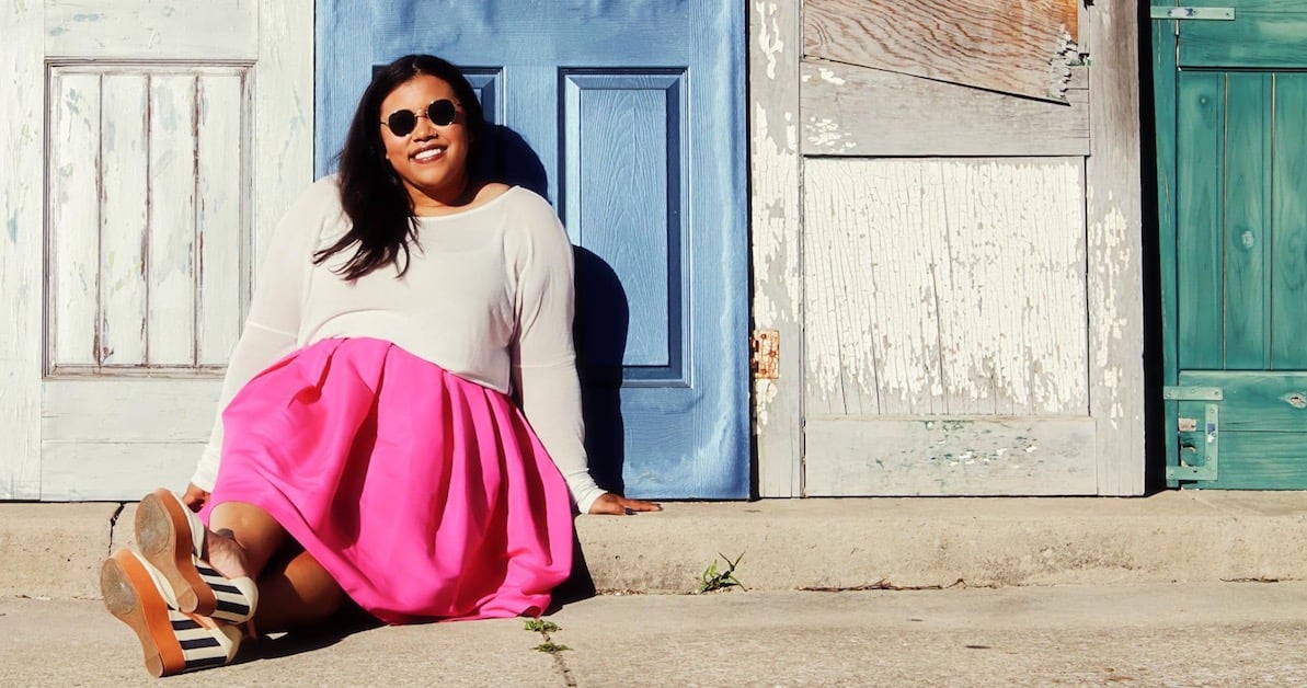 Sam Turner sitting in a pink skirt