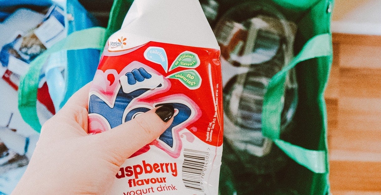 Woman recycling a milk bottle